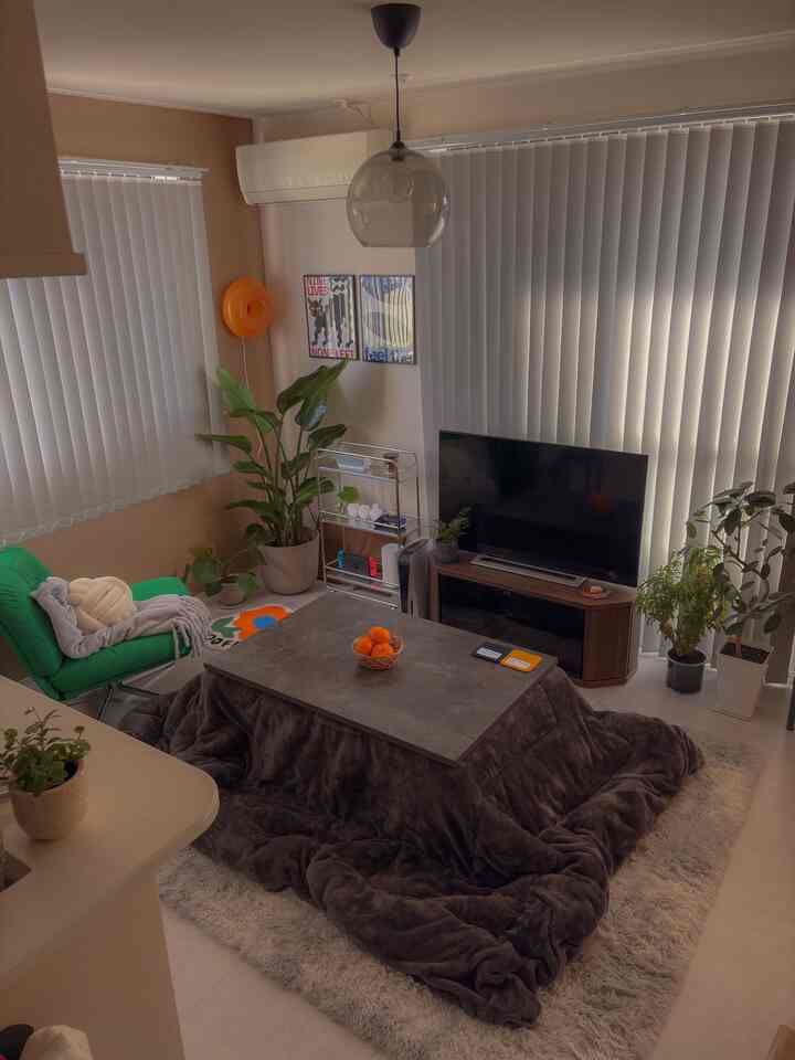 Brown and green toned 8-tatami living room featuring a kotatsu table and armchair in a cozy space