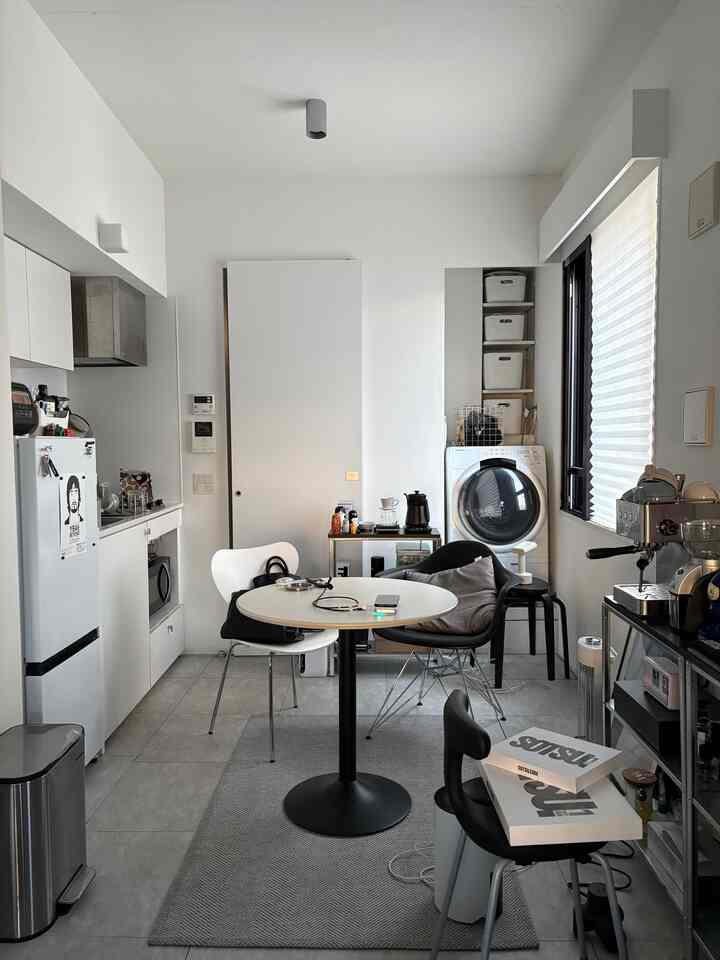 Monotone dining room in white and black featuring table, chairs, and coffee equipment in a compact, stylish space