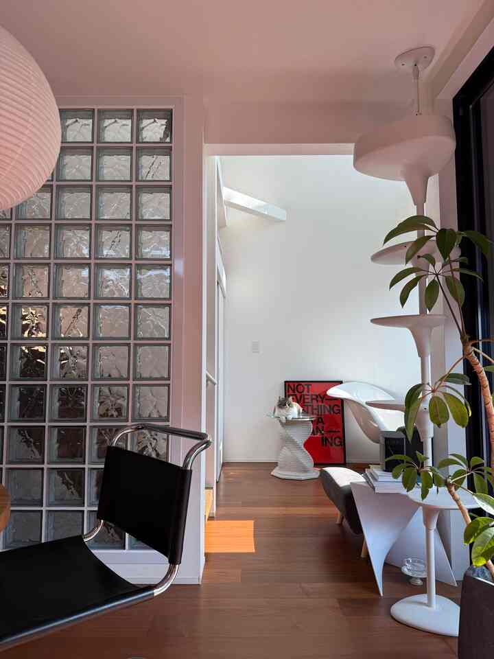 明るい白を基調としたリビング、ミッドセンチュリーモダンな家具とキャットタワーが配置された印象的な空間