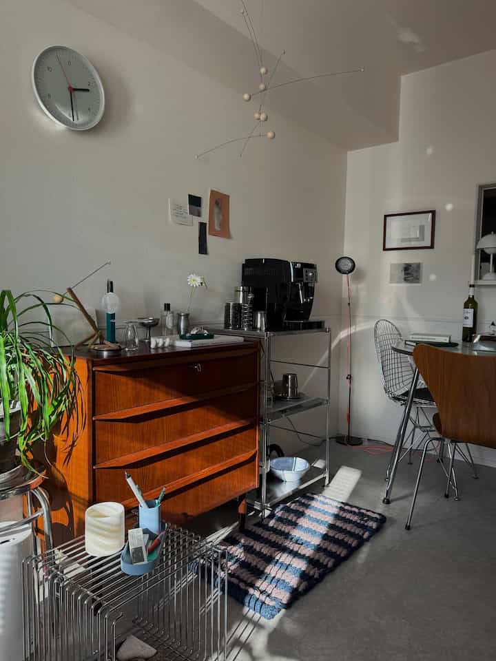 ナチュラルな色調の1LDKリビング、ヴィンテージのチェストとステンレス棚にコーヒーマシンが置かれた雰囲気あるおうちカフェ空間