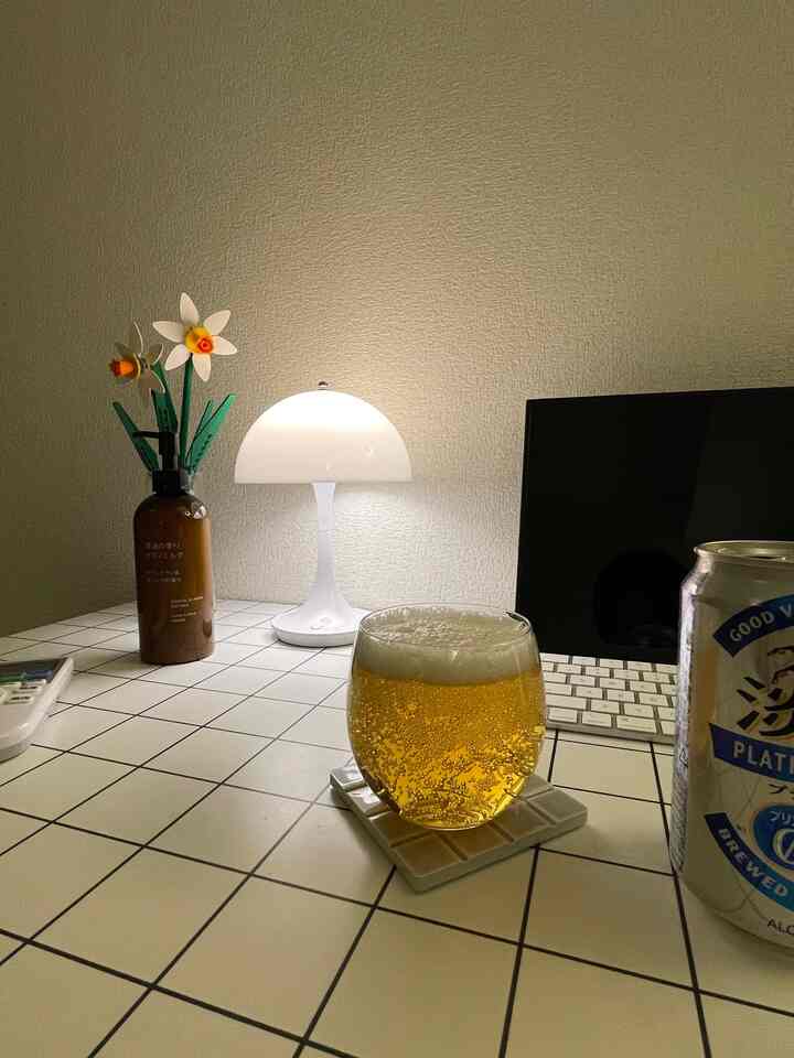 白を基調としたテーブルの上に飲み物と照明、装飾が置かれた居心地の良いおうちカフェの空間