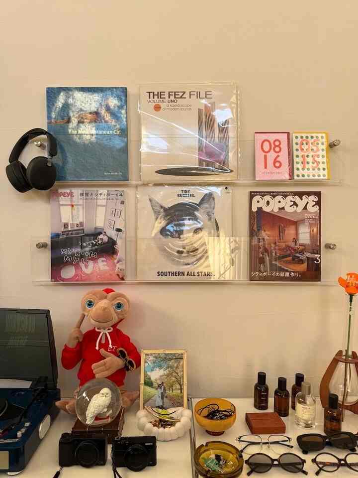 透明なアクリル壁棚にレコードや雑誌が配されたミッドセンチュリーモダンの印象的なインテリア