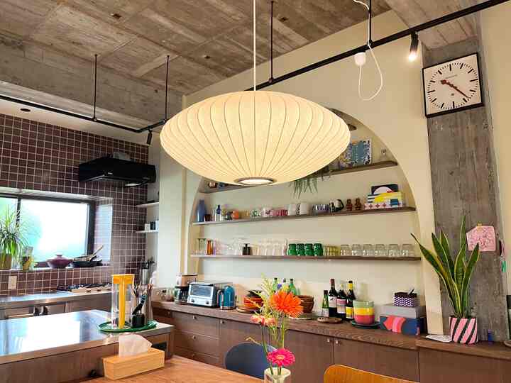 Natural wood tones with industrial concrete kitchen featuring a bubble pendant light and colorful kitchen accessories creating a cozy atmosphere
