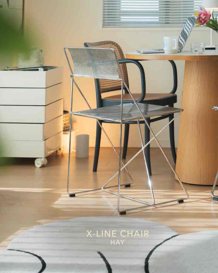 自然な木目調とシルバーの金属が調和したシンプルなリビング、木製のダイニングテーブルとクロームの椅子が配置された印象的な空間