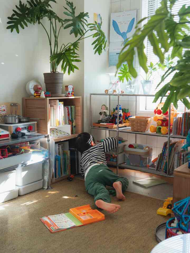 Beige-toned kids' room with natural light, featuring bookshelves and toy storage in a cozy setting