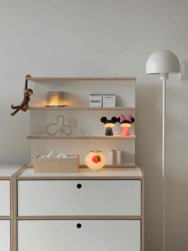 白とナチュラルカラーのリビング空間、テーブルランプとフロアランプが配置された印象的なインテリア