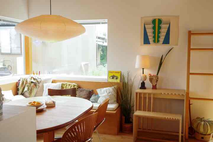Cozy dining room featuring natural wood tones and white walls, with a round dining table and Trinidad chairs arranged neatly