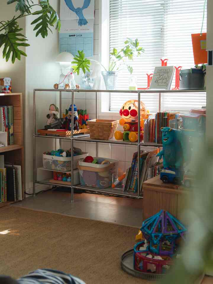 白とナチュラルカラーの子供部屋、ぬいぐるみ収納棚と子供向け本棚が整えられた明るく居心地の良いインテリア