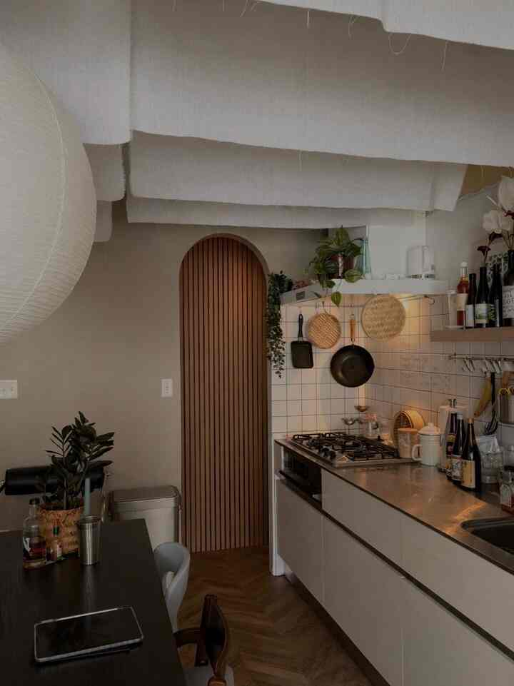 ブラウンとホワイトの落ち着いたキッチン、木製のダイニングテーブルと植物が配置されたレトロな雰囲気のインテリア