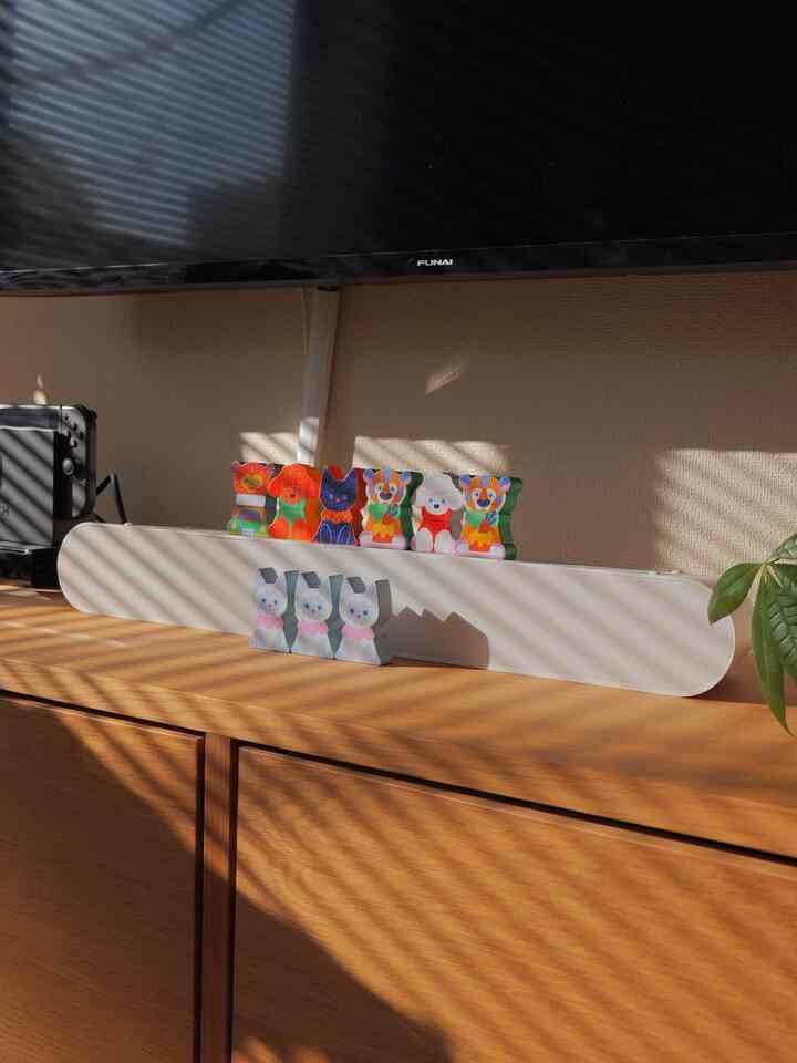 温かみのある木目調のリビング、白いサウンドバーの上に動物のオブジェが置かれた雰囲気のあるインテリア