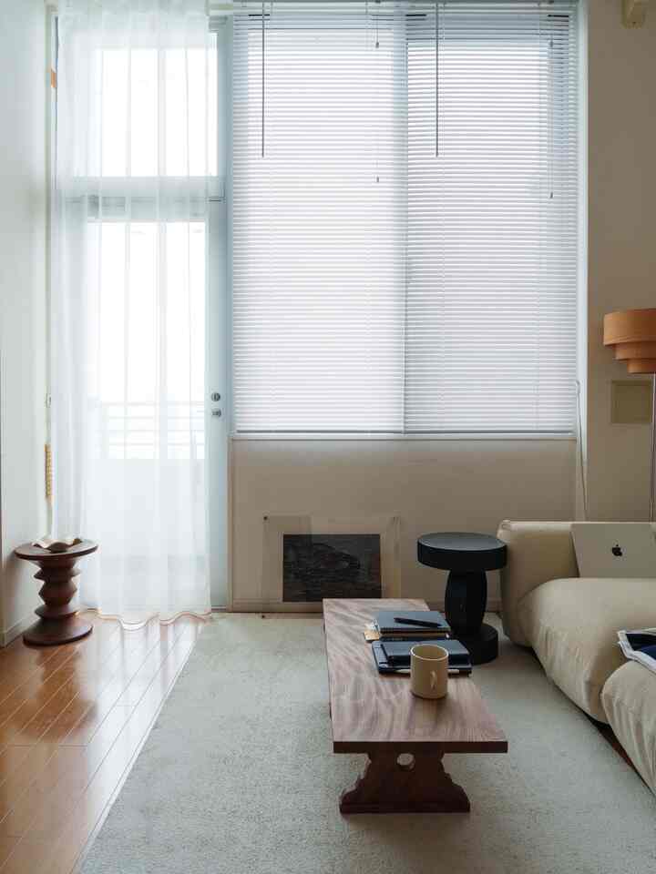 白と木目調のワンルームリビング、ローテーブルとソファが配置された自然な雰囲気のインテリア