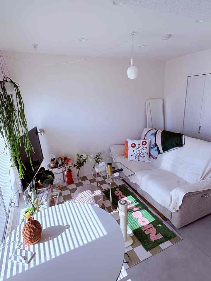 白を基調としたリビング、ゆったりとしたソファと丸テーブルが配置された落ち着きのある空間