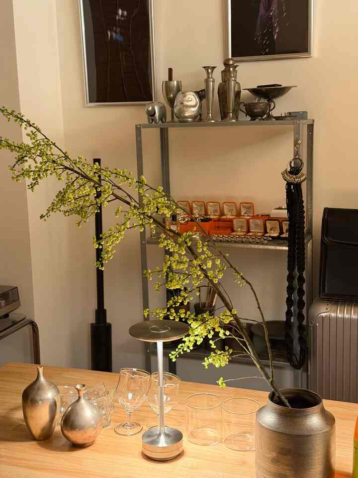 ナチュラルな木製テーブルとヴィンテージ調の金属オブジェが配置された一人暮らしの印象的なアクセサリーコーナー