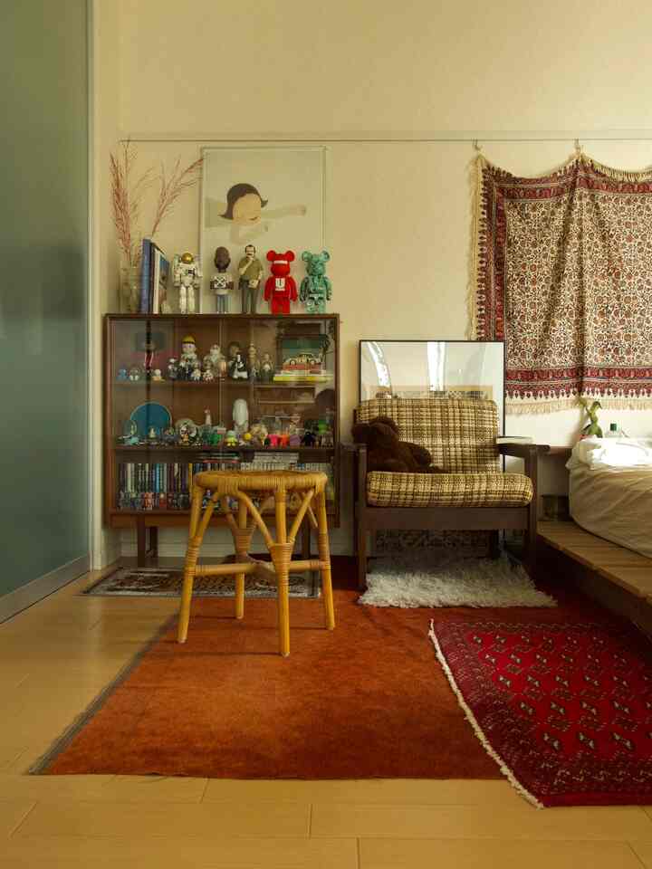 Warm natural tone mid-century modern bedroom featuring wooden furniture and colorful collectibles in a cozy setting