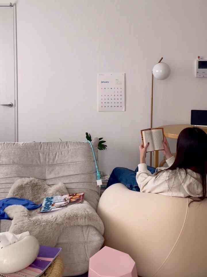 ナチュラルトーンのリビング、ビーズクッションとソファが配置され、落ち着いた読書の雰囲気のある空間