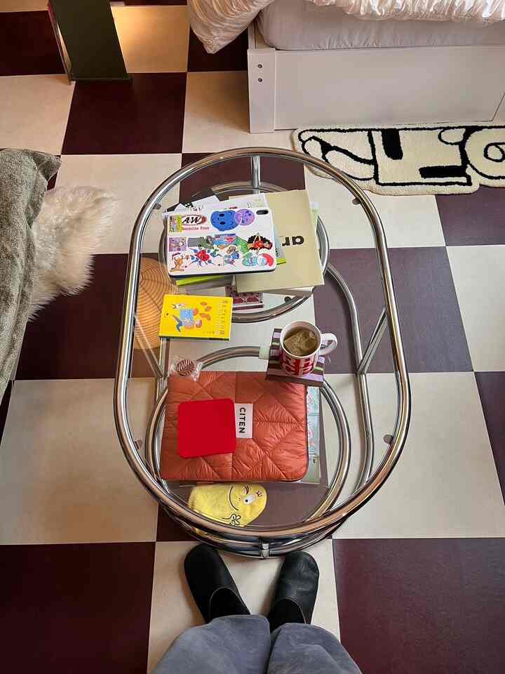 Brown and white checkerboard floor with a glass-top coffee table in a minimalistic home cafe space
