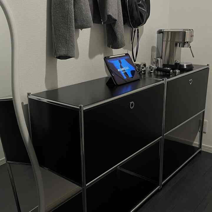 Black cabinet placed in a small studio apartment space, conveying a simple and modern atmosphere