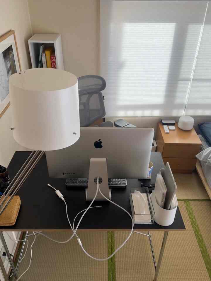 ナチュラルカラーの狭い一人暮らし用ワークスペース、Macモニターとデスク、グレーのオフィスチェアが整然と配置されたインテリア