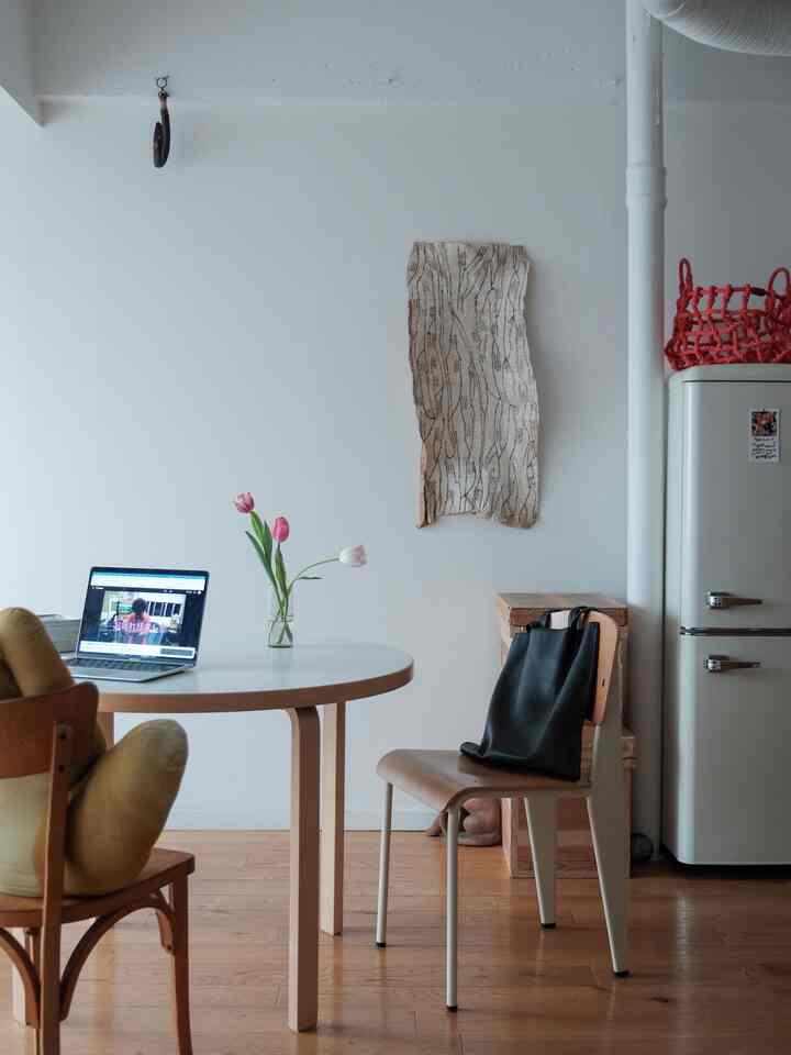 白い壁と木目調の床が特徴の6畳スタジオ、丸いダイニングテーブルと椅子が配置されたモダンでナチュラルなホームカフェ空間