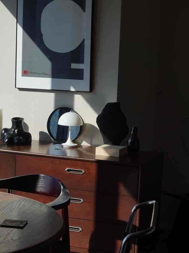 ブラウンの木製家具と白いテーブルランプが配置された、自然な雰囲気のダイニング空間