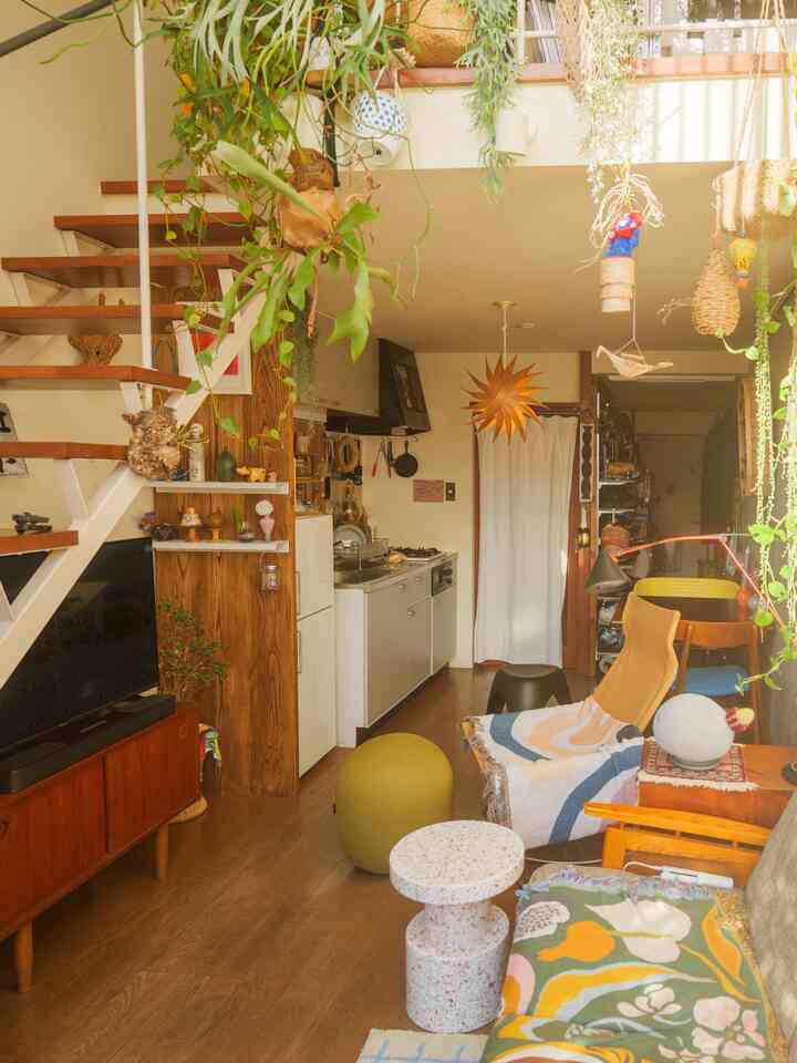 Natural-toned Nordic living room and kitchen combined space featuring plants and wooden furniture creating a cozy atmosphere