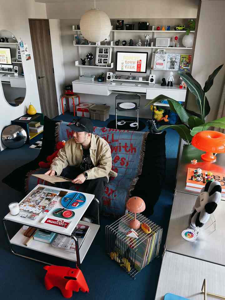 Compact single household home office and living room featuring blue carpet floor and black sofa with modern layout