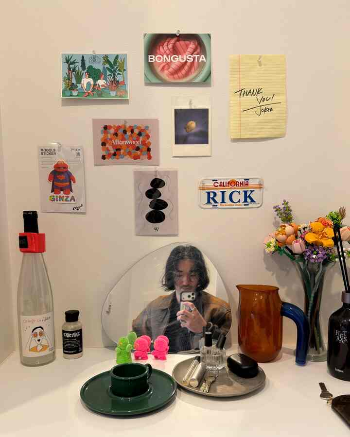 白を基調とした玄関の壁に多様なウォールデコとオブジェが配置された、ナチュラルでミニマルな印象的な空間