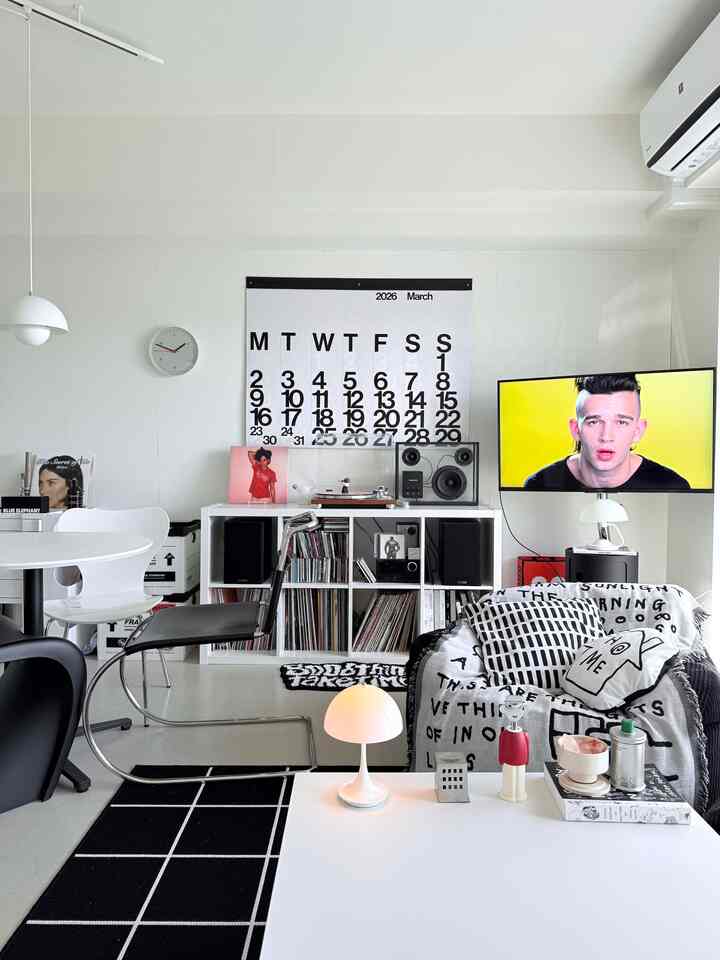 白と黒のトーンのリビング、モダンな家具と大きなカレンダー、テレビが配置された印象的な空間