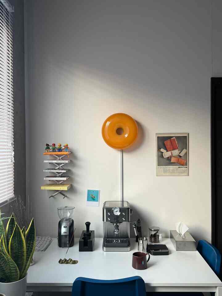 ホワイトのテーブルと植物があるキッチンスペース、エスプレッソマシンとキッチン用品が配置された清潔感のあるおうちカフェのインテリア