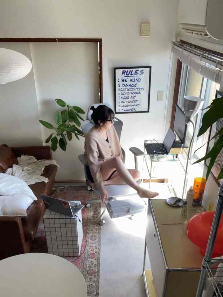 White and brown tone living room for a single household, featuring mid-century modern sofa and a remote work desk in a cozy setting