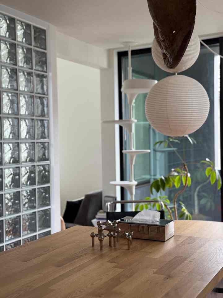 White and wood tone living room featuring mid-century modern pendant light and cat tower with cozy atmosphere