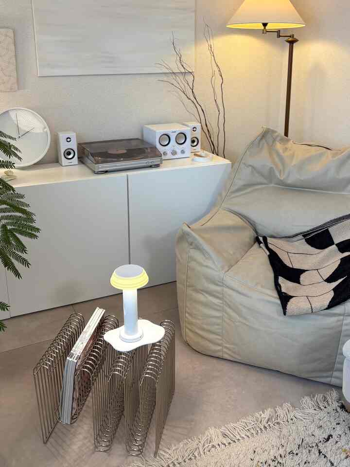 ベージュとホワイトの色調のリビング、ビーズクッションソファとオーディオ機器が配置されたモダンで清潔感のあるインテリア