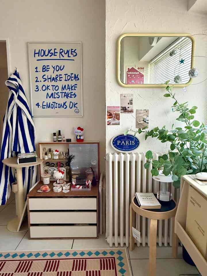 白とナチュラルカラーのリビングコーナー、収納チェストとサイドテーブル、植物が配置されたシンプルな空間