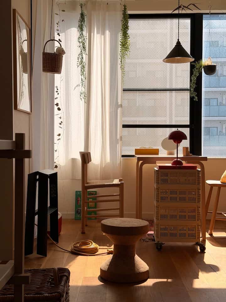Natural wood tones and white curtains in a dining room bathed in warm sunlight, creating a cozy atmosphere