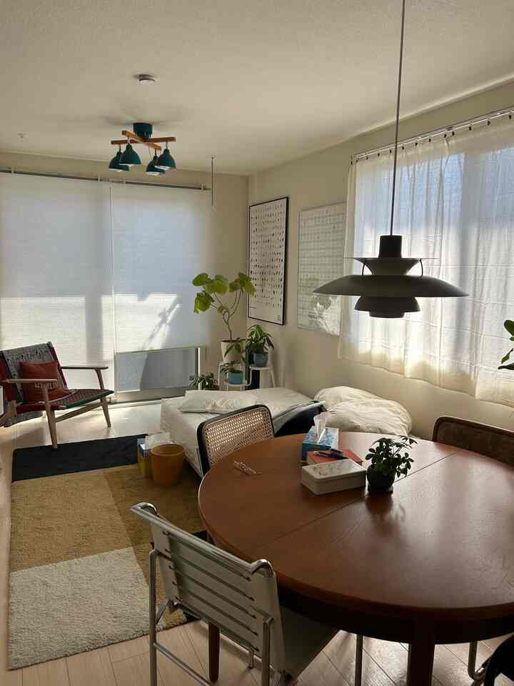 Natural light-filled living and dining space featuring wood tones and mid-century modern furniture