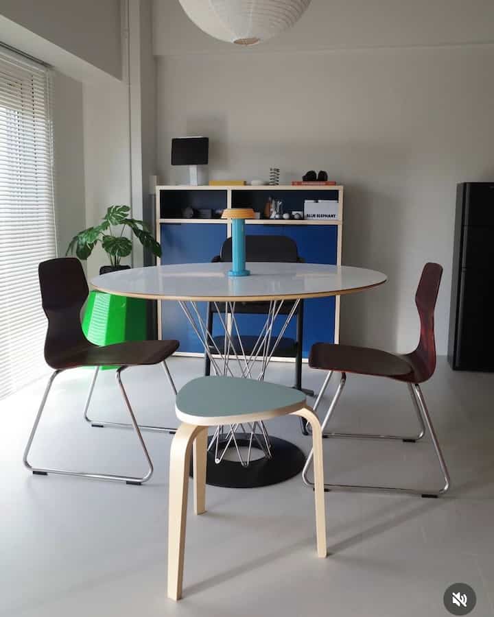 白と青の色調のダイニング、丸いテーブルと木製の椅子が配置された清潔感とレトロな雰囲気のあるインテリア