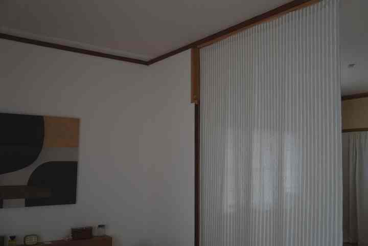 Beige and white toned living room featuring striped curtains and decor with a warm, cozy atmosphere