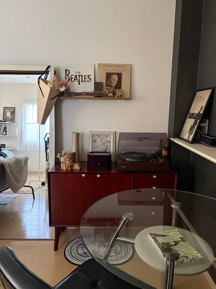 Wood tone vintage living room featuring a reddish-brown cabinet and a glass table, creating a cozy atmosphere