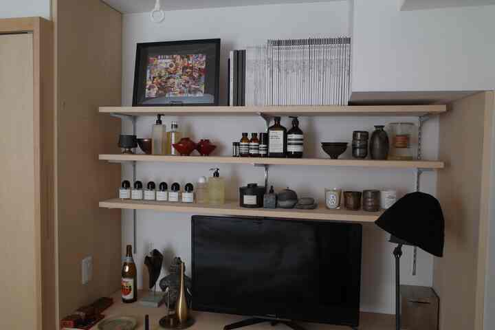 白と木目調の1人暮らし空間、棚とテレビ台が配置された印象的なシンプルなインテリア