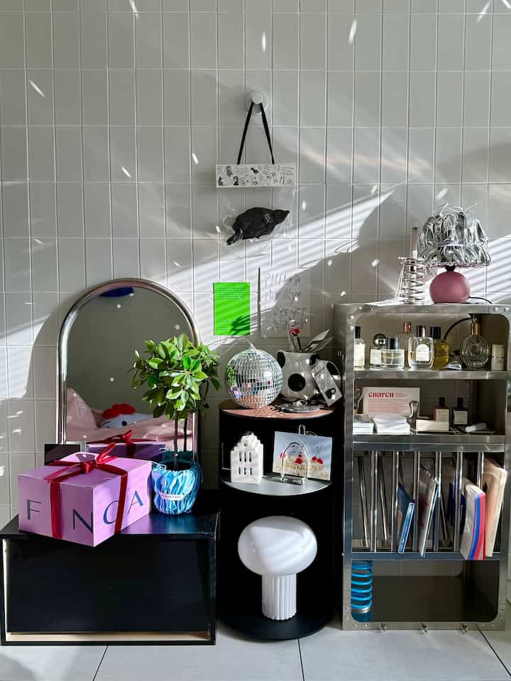 Minimalistic living room corner with silver metallic storage, sky blue plant pot, and side table under natural light
