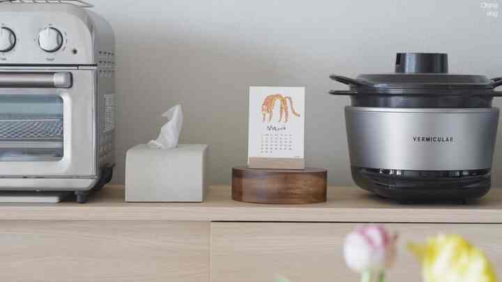 シルバーの調理器具と木目調の棚が調和したミニマルなキッチン空間