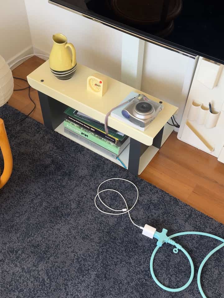 White and gray toned living space featuring a mini bench shelf and dark rug in a minimalistic setting