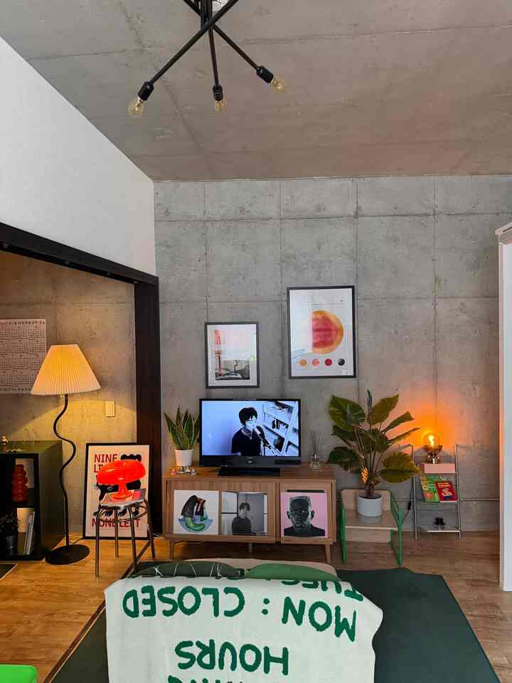 ナチュラルな色調のワンルームリビング、緑の植物と木製家具が調和した温かみのあるインテリア