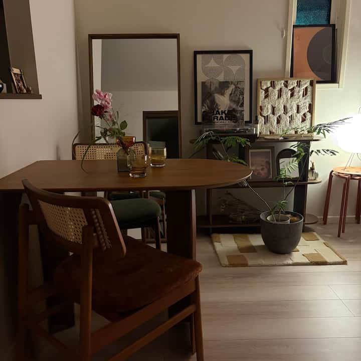 温かみのある木目調のダイニング、木製のテーブルとラタンチェア、照明が調和した落ち着いた空間