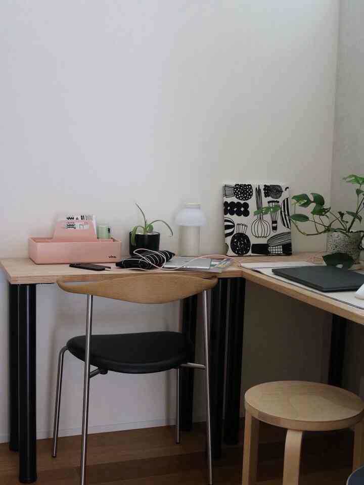 A compact home office space with white walls and wood-tone furniture