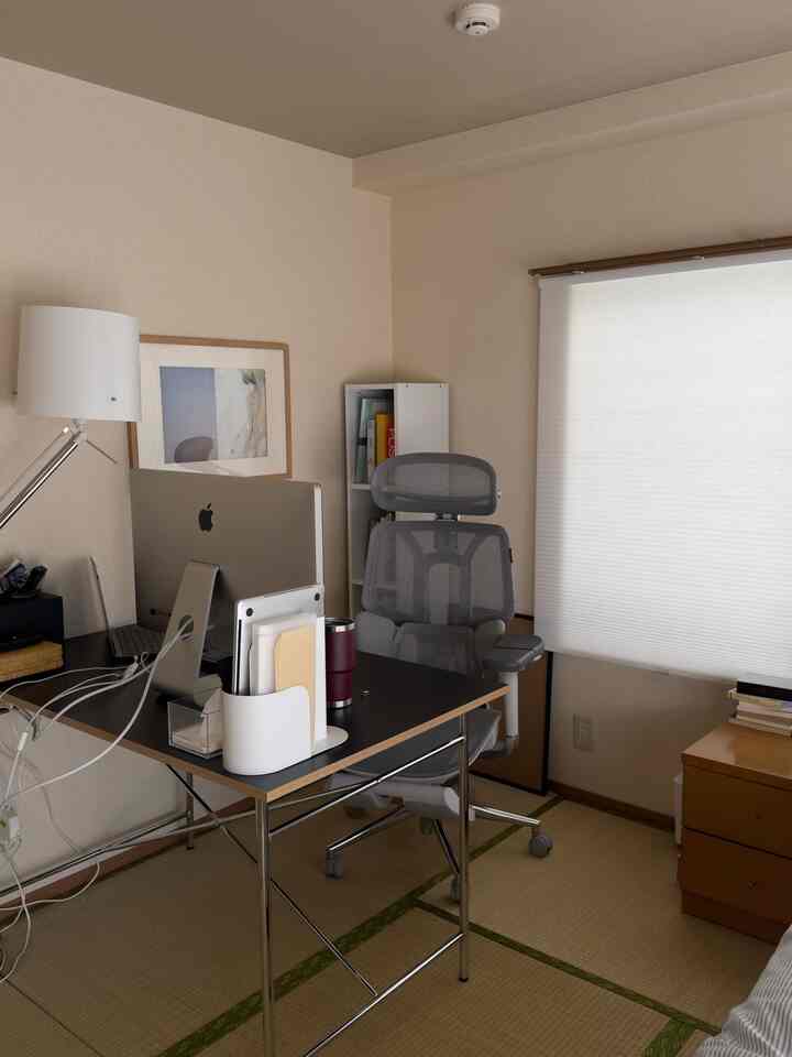 A white-walled 6-tatami mat room featuring a black desk and gray office chair in a home office setup