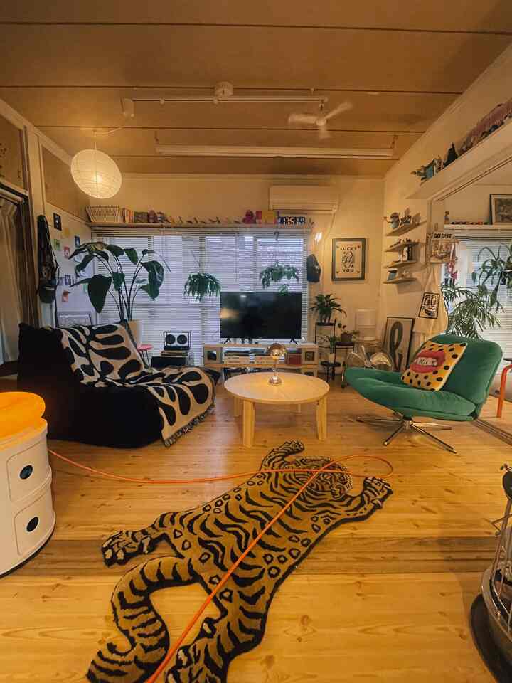 暖かい木目調とグリーンのラウンジチェア、チベタンタイガーラグが印象的なリビング