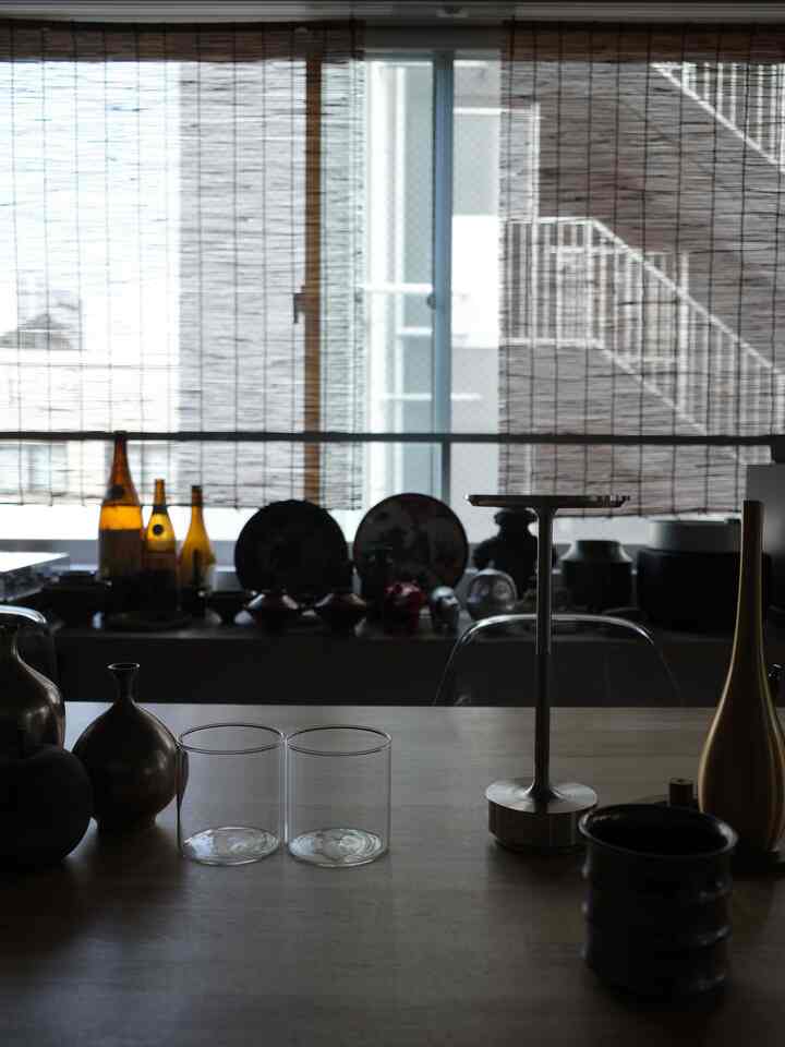 ナチュラルな木目調と透明なグラスが置かれた一人暮らしの1LDKダイニング、照明と花瓶が調和したモダンな空間