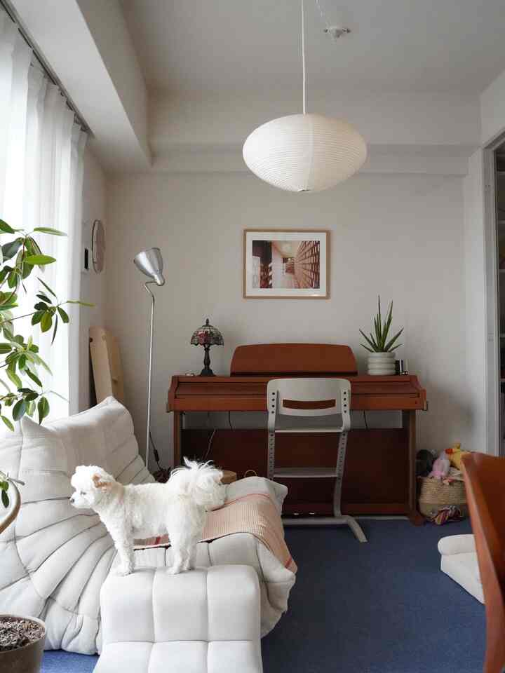 White and natural brown toned living room featuring sofa and piano with a natural modern atmosphere