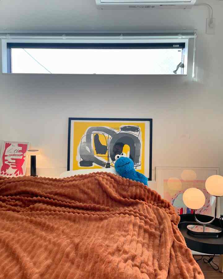 Warm brown-toned bedroom featuring large artwork and table lamps creating a cozy atmosphere